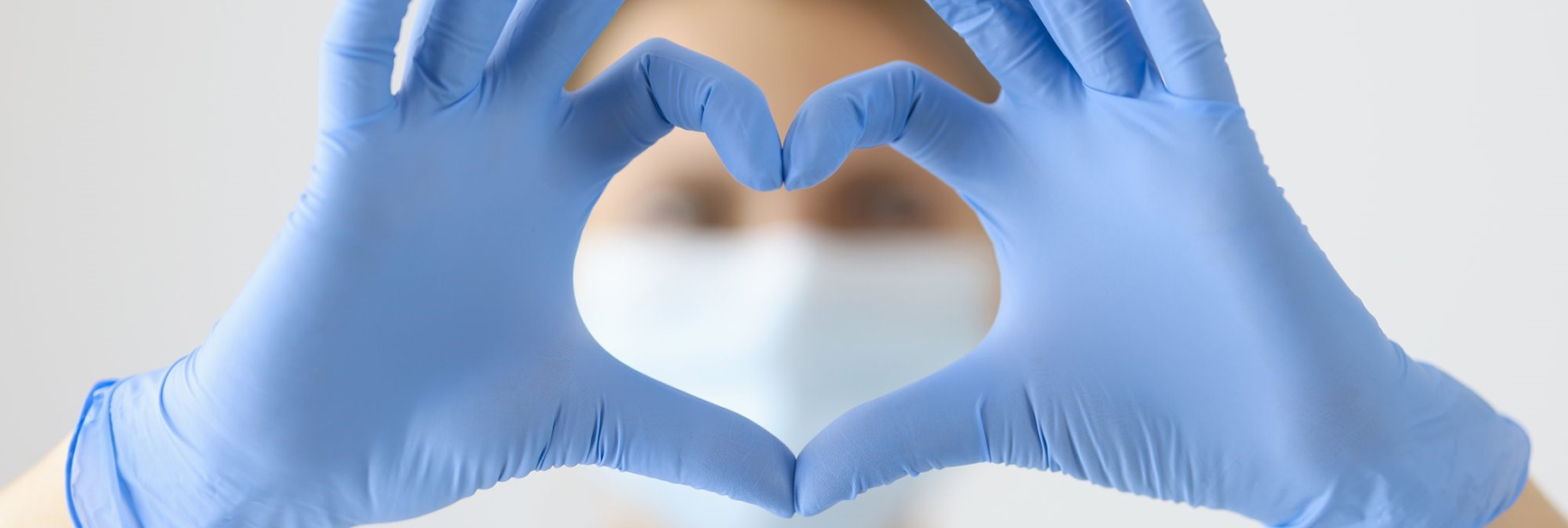 Herz Symbol Header Hände mit blauen medizinischen Handschuhen formen ein Herzsymbol